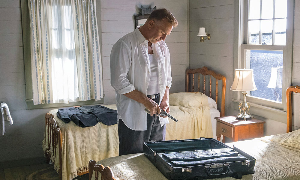 kevin costner in the highwaymen with a gun by a bed true west magazine