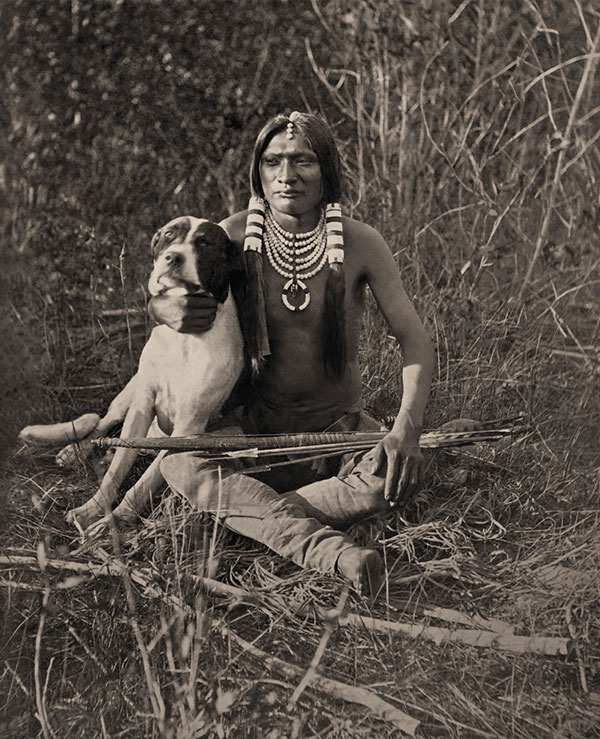 uinta ute boy and his dog in a field with arrows true west magazine