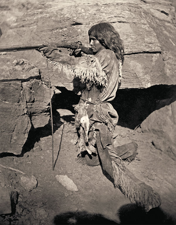 native american man with a gun on rocks true west magazine