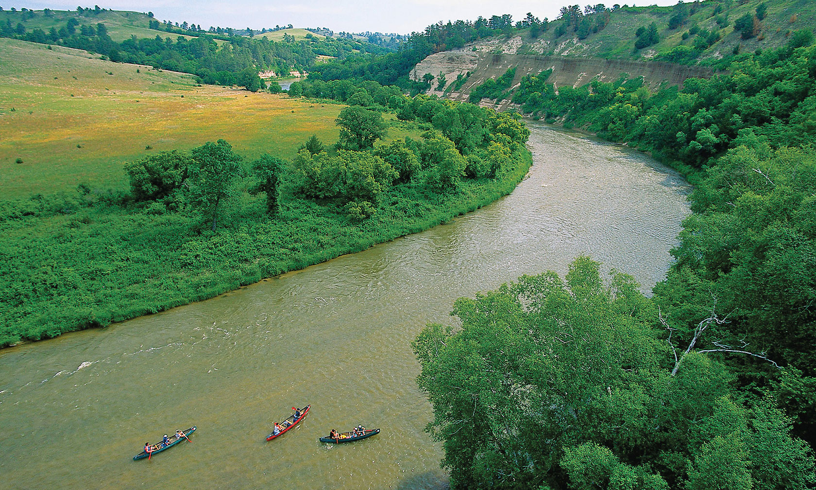niobrara river valley with trees and kayaks true west magazine